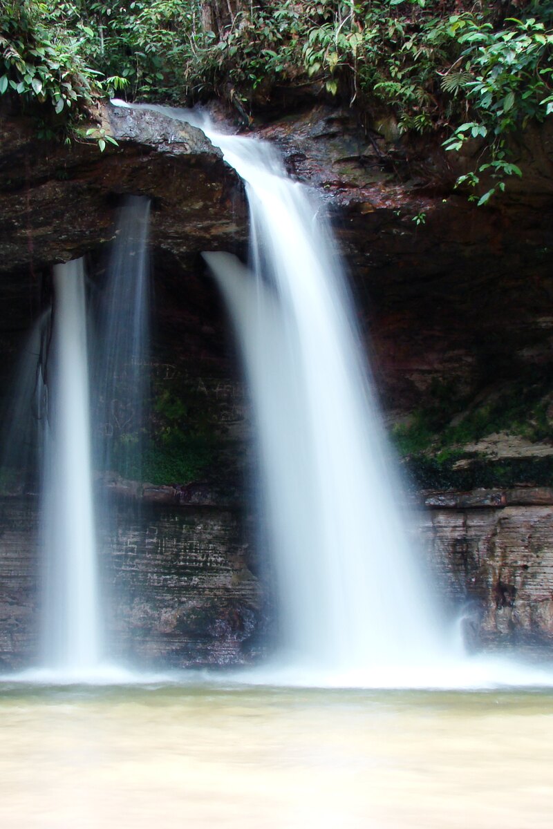 Duas quedas da Cachoeira da Pedra Furada descendo o paredão de arenito até o poço