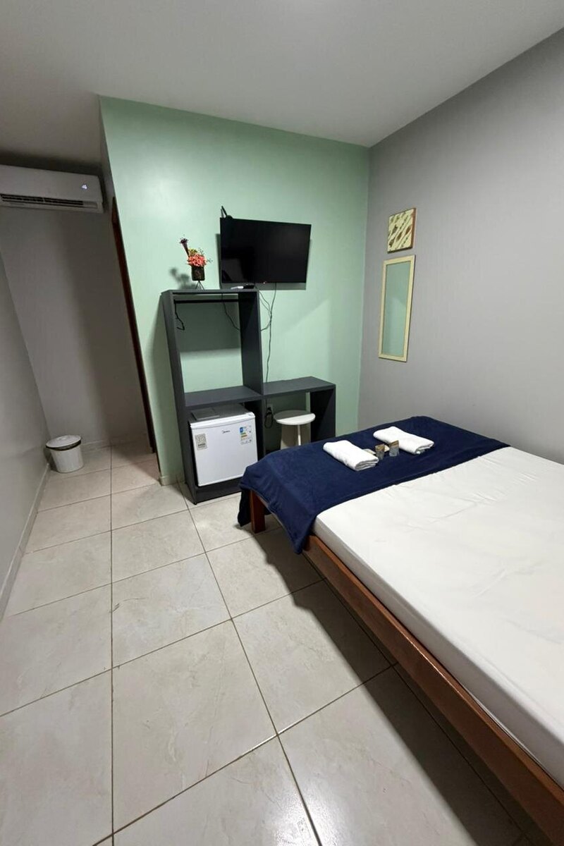 Quarto com cama, televisão, frigobar e ar-condicionado