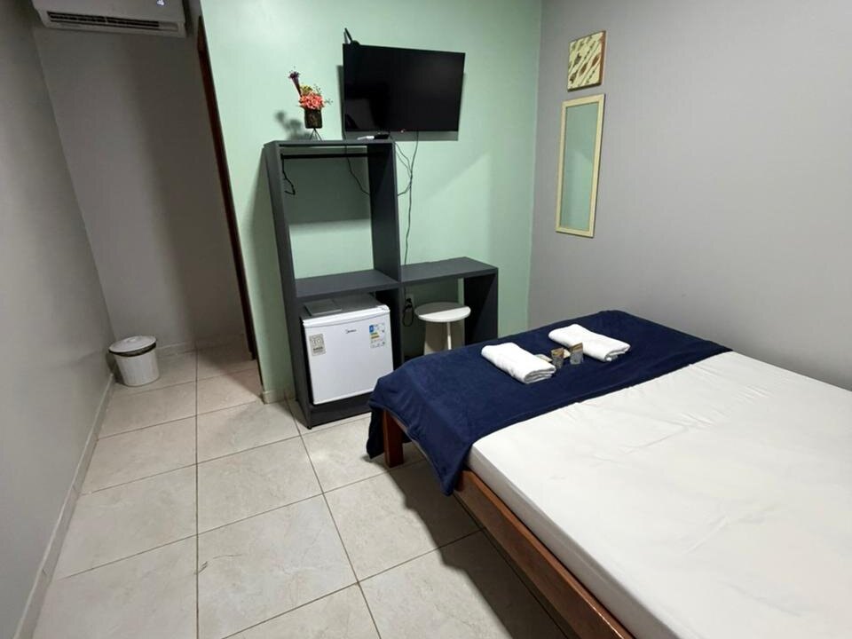 Quarto individual com cama de solteiro e frigobar